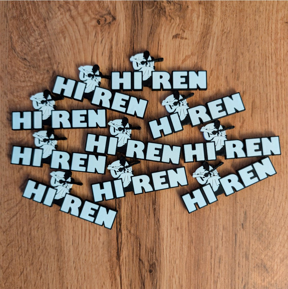 Multiple 'HI REN' magnets scattered on a wooden surface